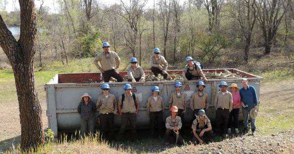 CCC members and volunteers fill one of the dumpster with invasive plant debris.